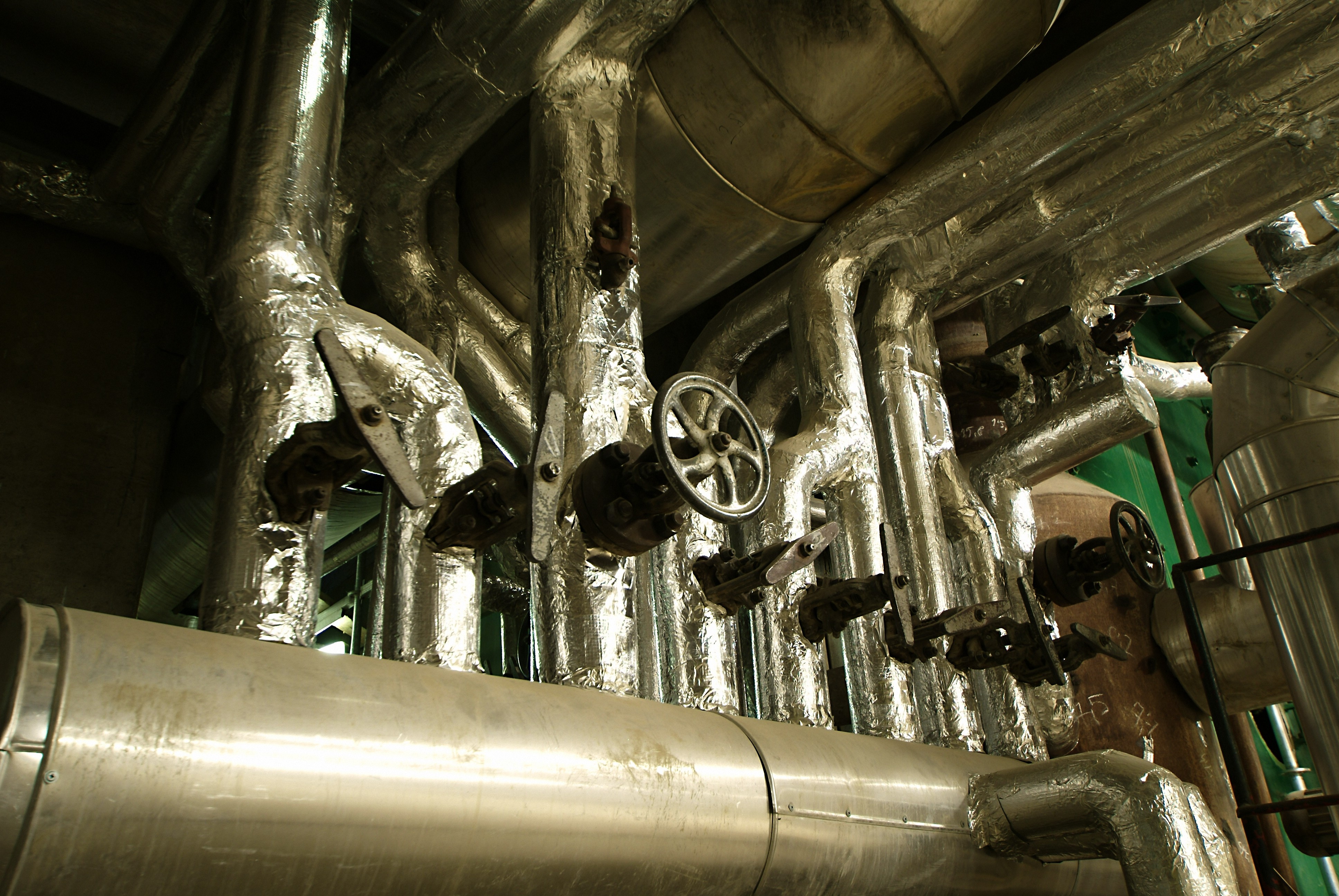 Reflective foil insulation on pipes in a tight mechanical room