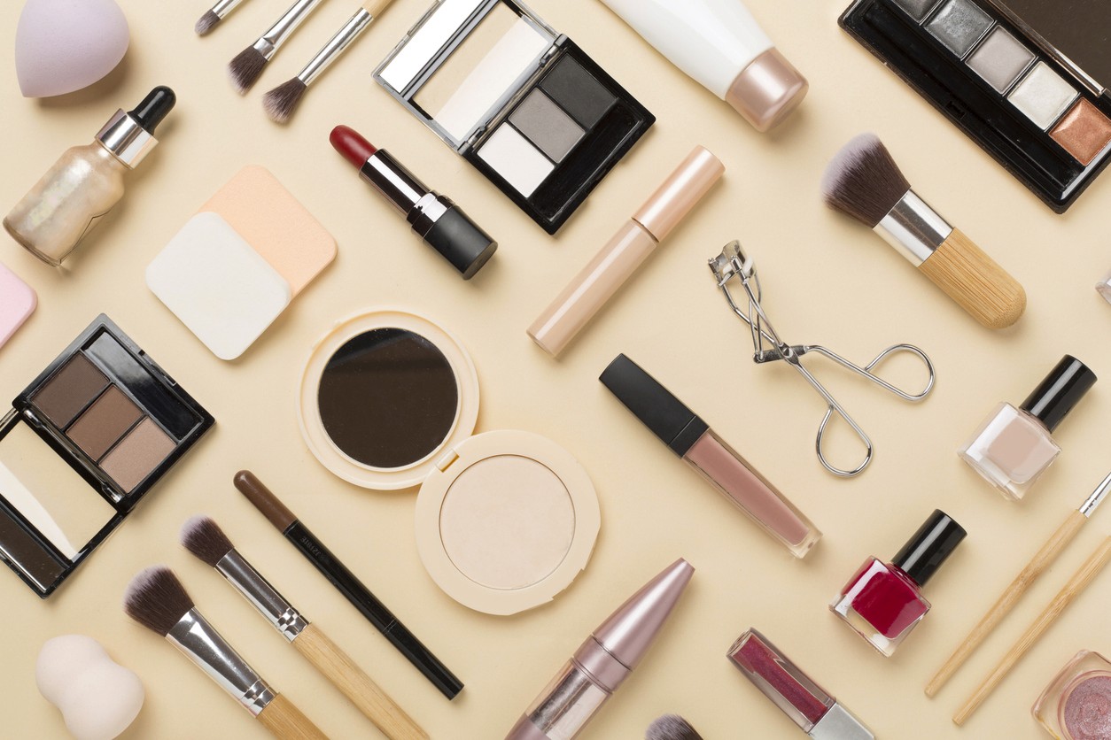 Overhead view of cosmetic products laying on a table and nicely organized in a grid