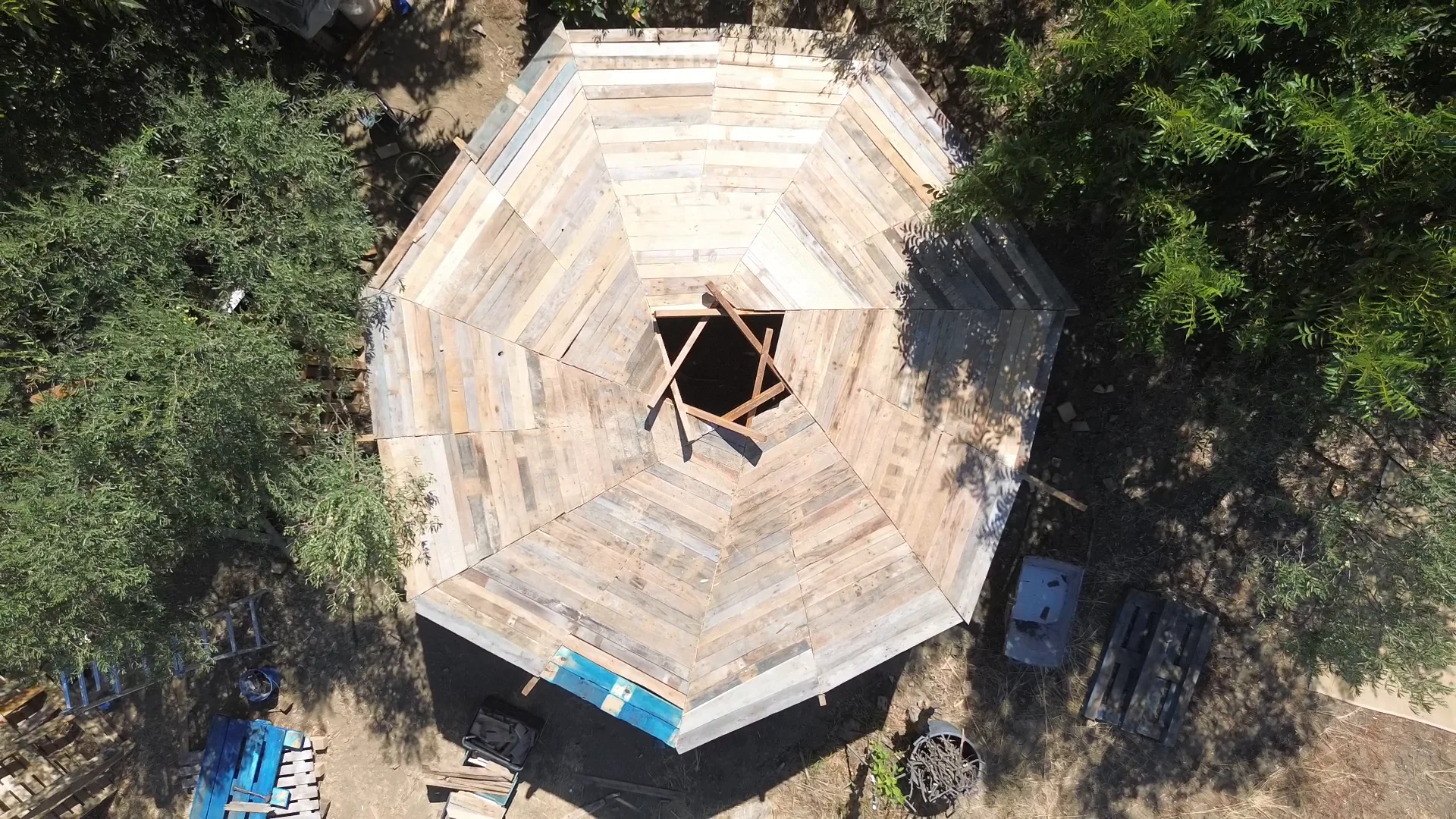 Aerial view of an octagonal timber roof among trees