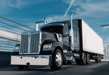 Black semi-truck driving on bridge representing semi truck insurance cost.