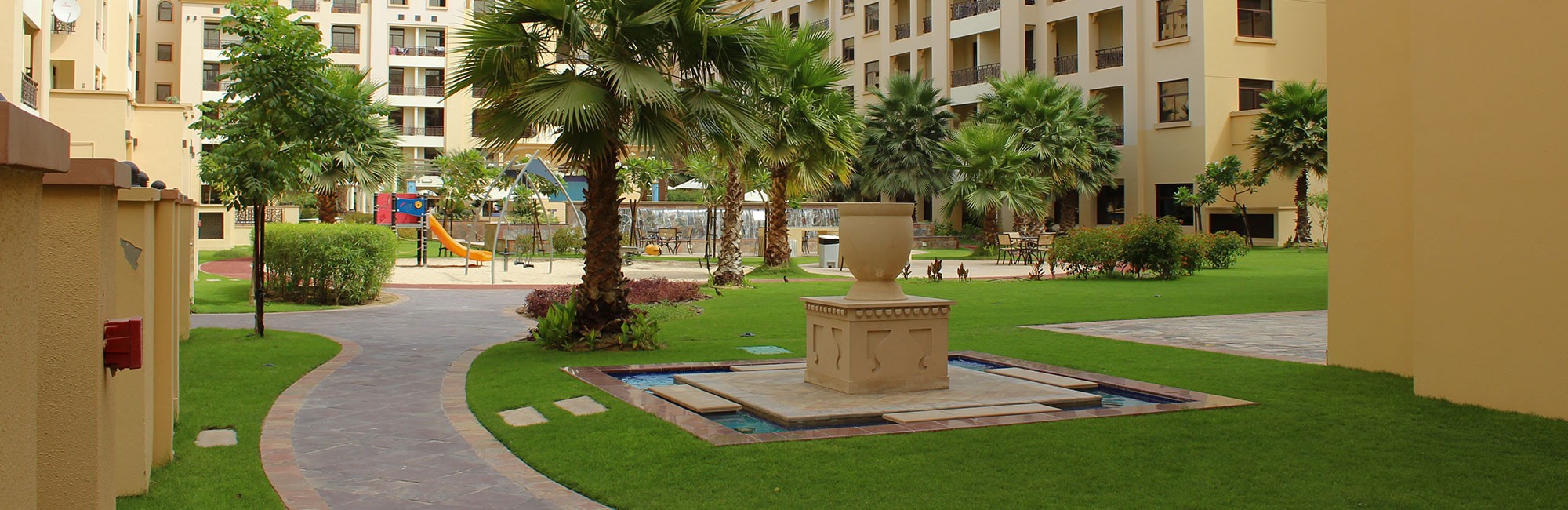 The Square by OMNIYAT showcases a park with a fountain and playground, nestled within a residential neighborhood.