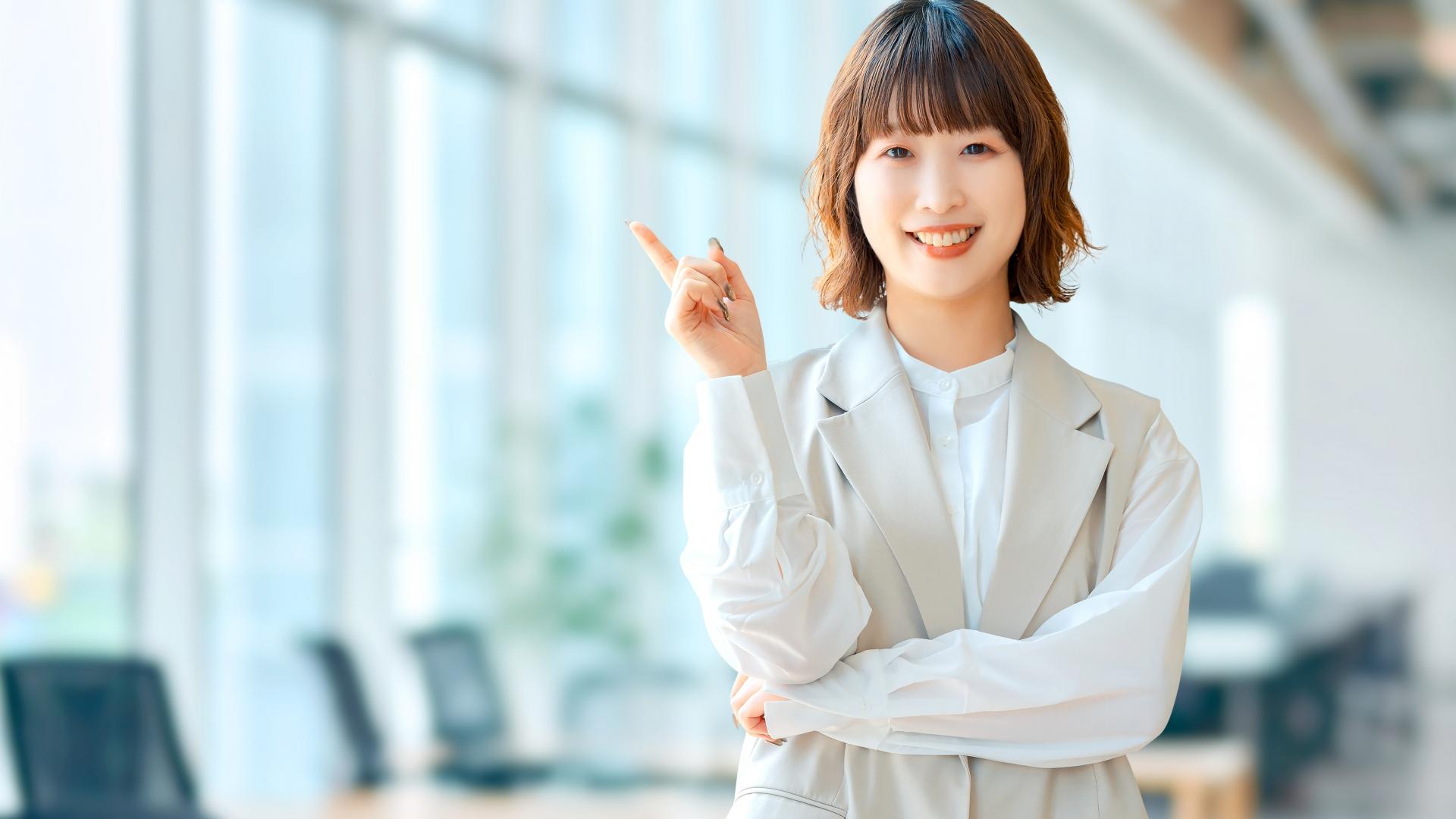 指をさして説明する笑顔の女性