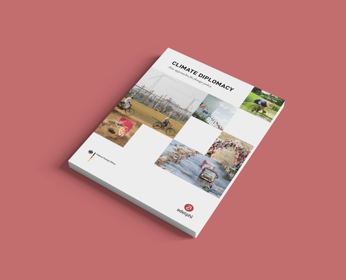Angled editorial mockup showing the cover design of the Climate Diplomacy policy report on a light red background.