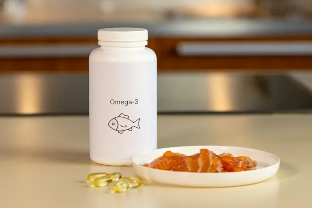 Omega-3 Fatty Acids supplement bottle next to plate with salmon