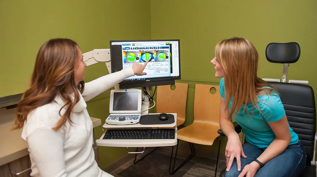 Optometrist Dr Ward showing patient 3D imaging results during an eye exam