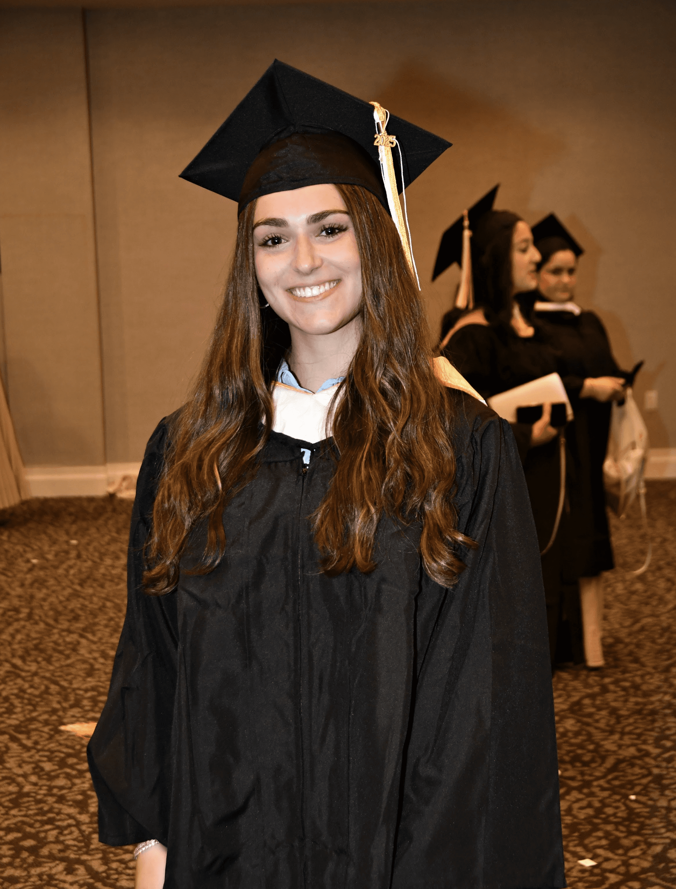 man holding the back of his head while smiling near brick wall