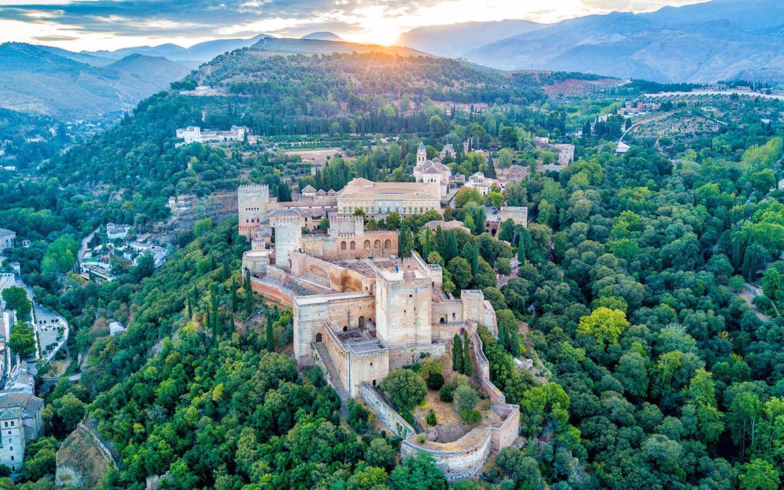 西班牙格拉纳达，阿尔罕布拉宫和赫内拉利费的鸟瞰图，被郁郁葱葱的绿色植被所环绕。