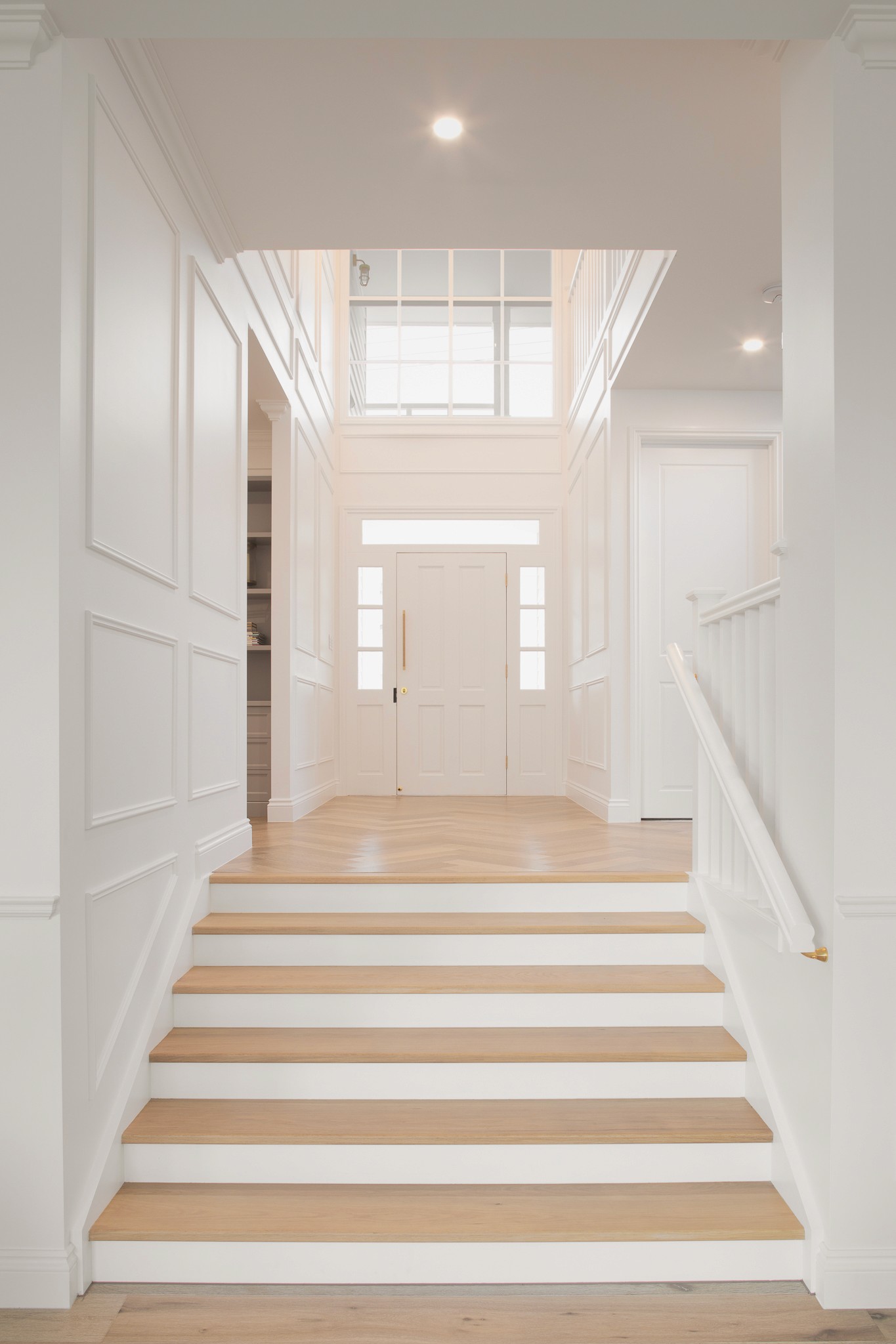 Split level design with stairs leading to the front door and wainscoting on the walls