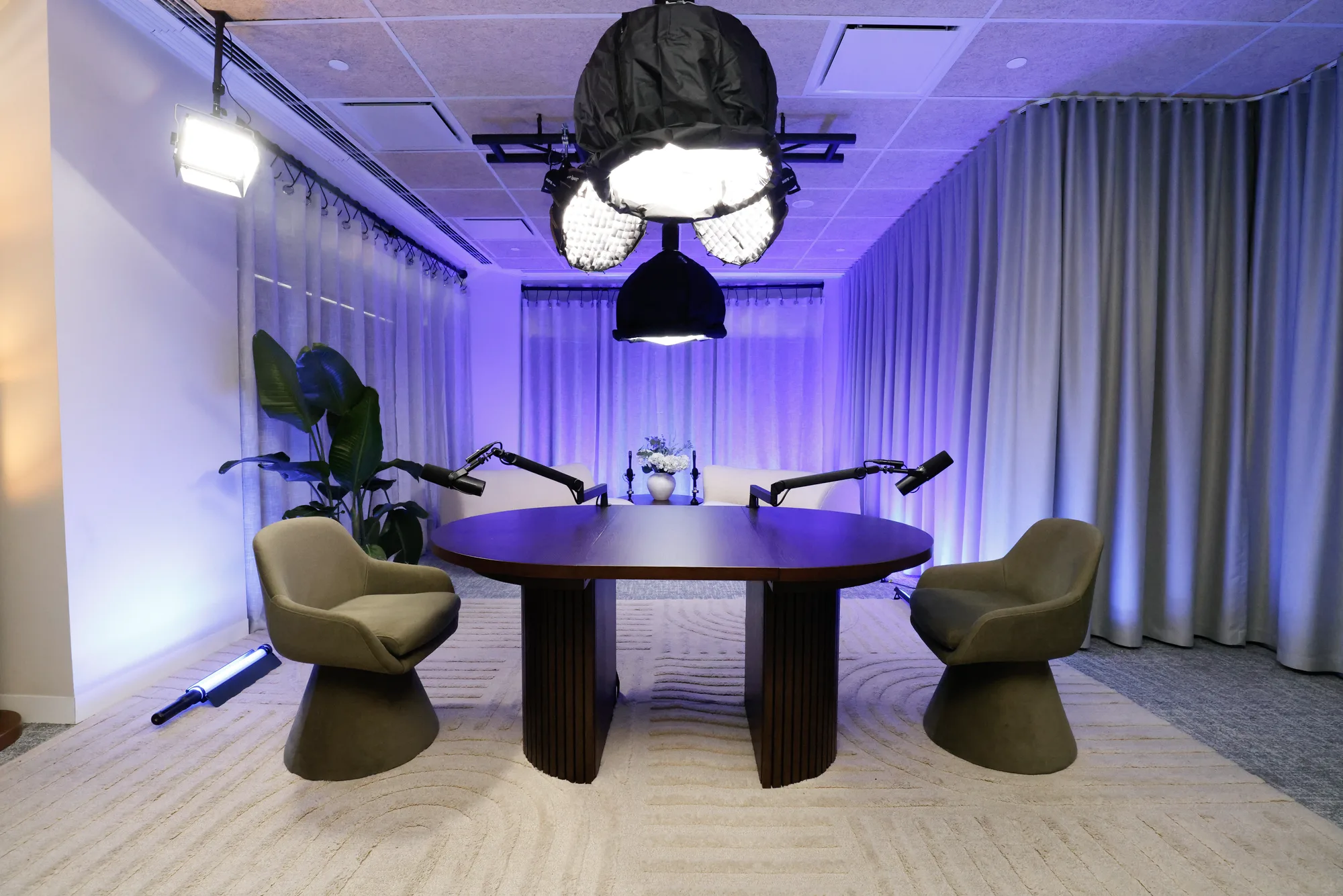 Wide view of the OAK set — dark round table and green chairs, warmly lit