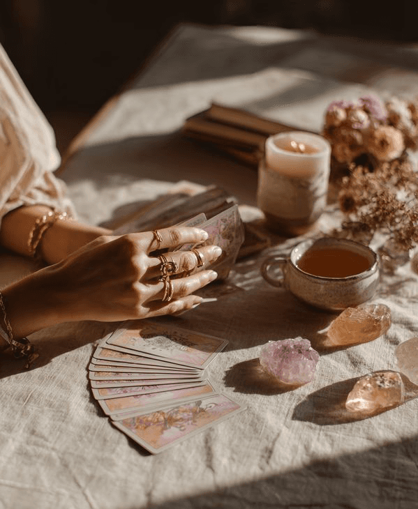 A person with curly hair sits at a desk, working on a laptop in a cozy, well-lit environment.