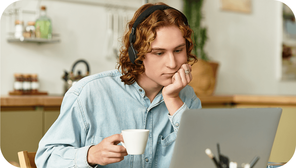 Student wearing headphones to minimize distractions and focus on a laptop, illustrating an ideal study environment.