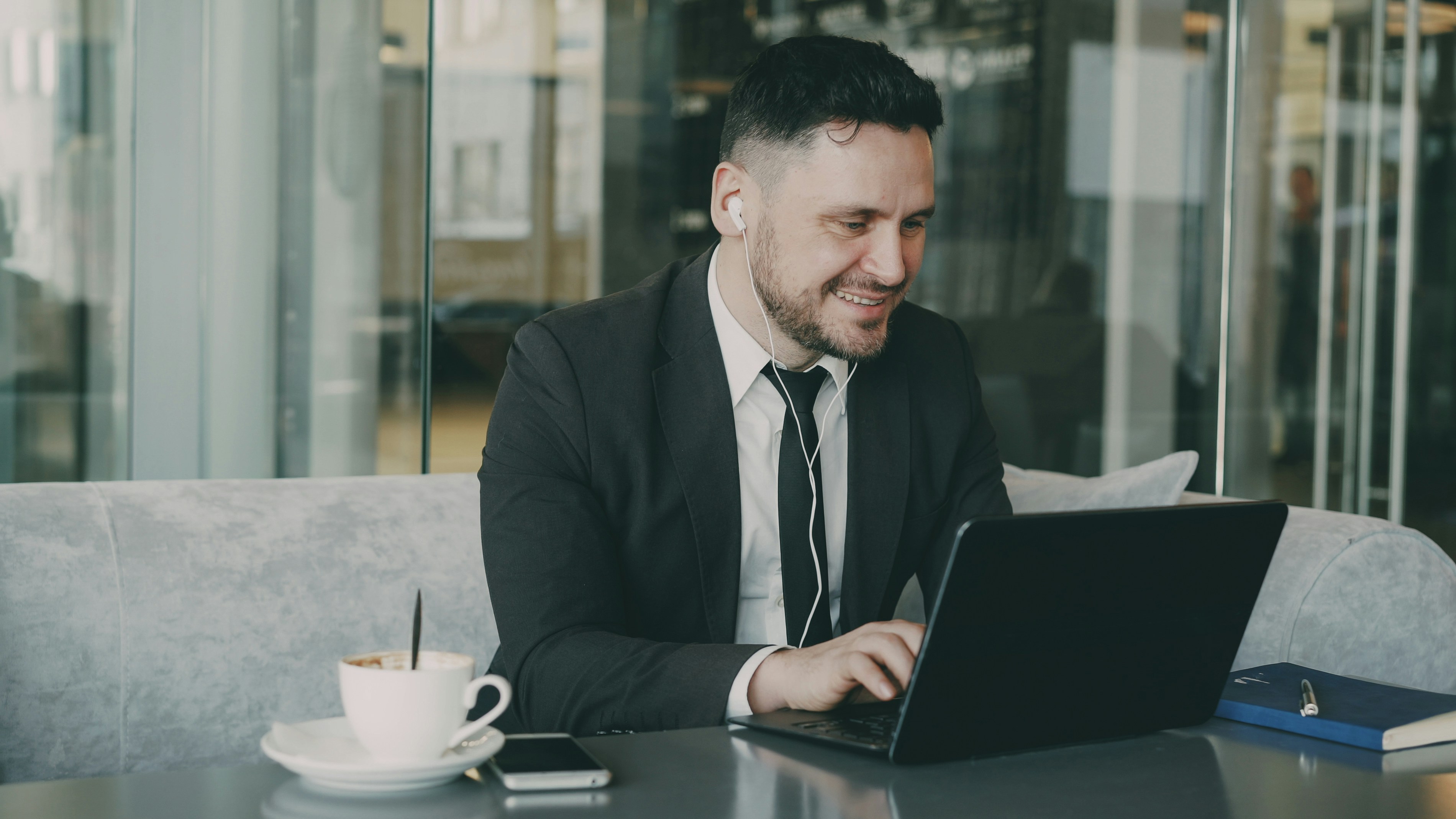 Man in suit working on laptop in cafe
