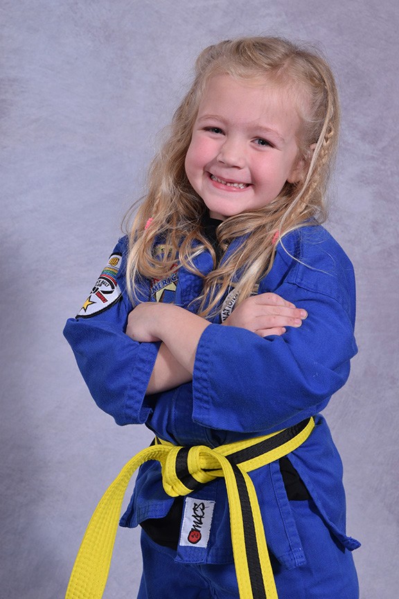 After School student posing arms crossed with her blue martial arts uniform