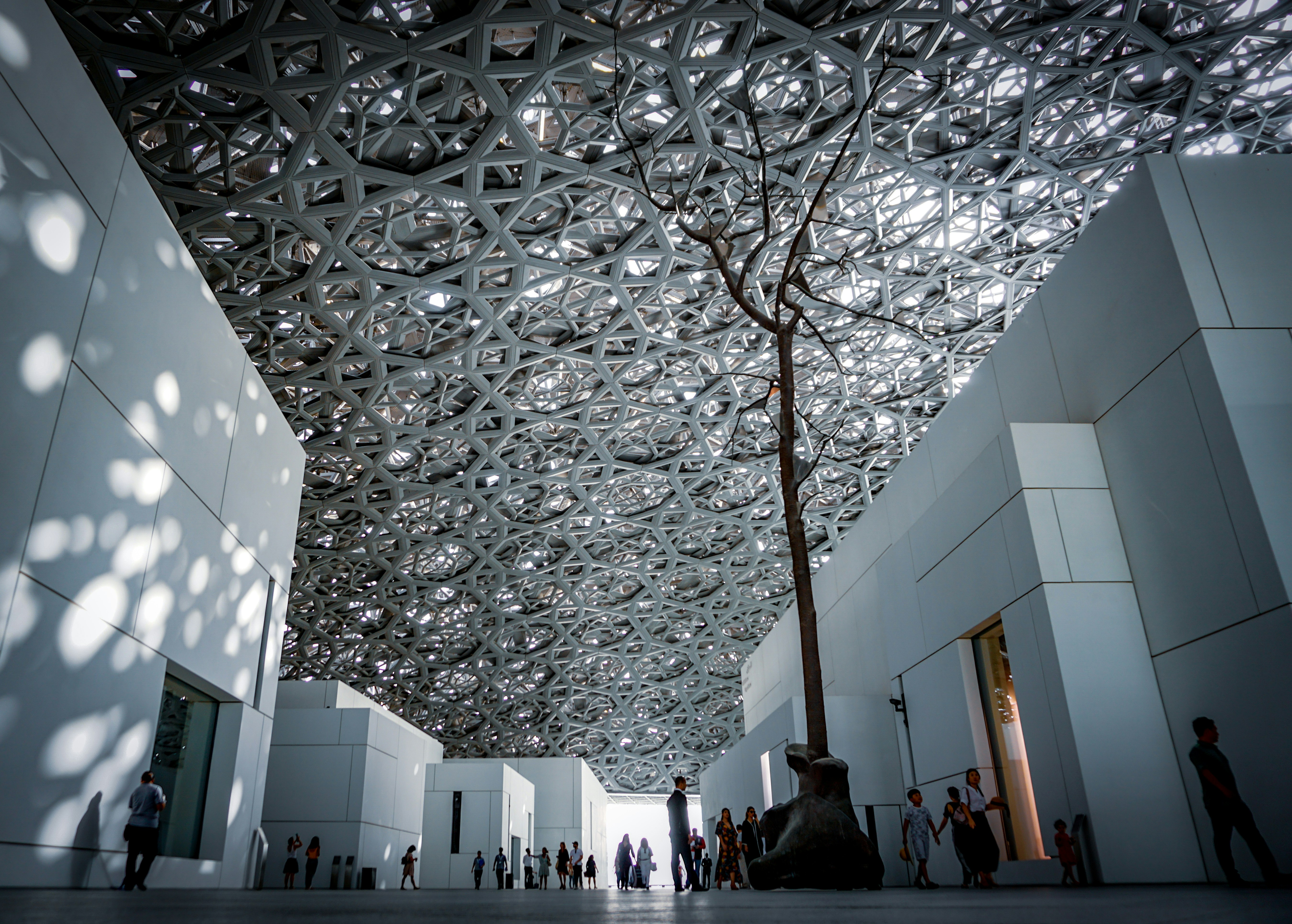 people standing under the dome of Louvre Abu Dhabi