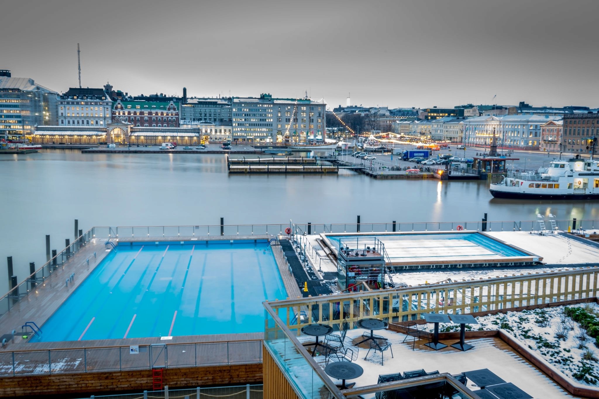 The port of Helsinki with a bright blue swimming pool in the docks and snow all around