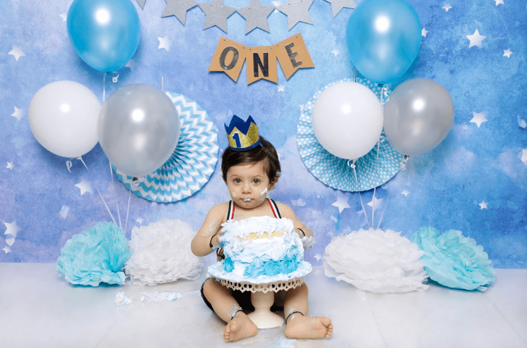 Baby boy posing for his first birthday cake smash photoshoot.