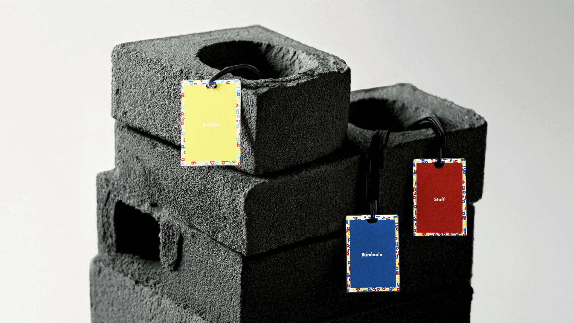 Un ensemble de cartes d'identification colorées (jaune, bleu, rouge) représentant différents rôles : artistes, staff et bénévoles. Cette image symbolise l'inclusivité du festival et la diversité des participants, tout en donnant un aperçu de l’aspect pratique et convivial du rebranding.