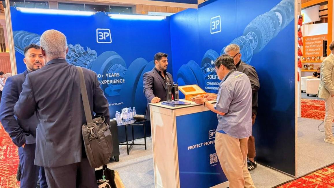 People at the 3P trade show booth, discussing products and services. The display features the company logo and years of experience.