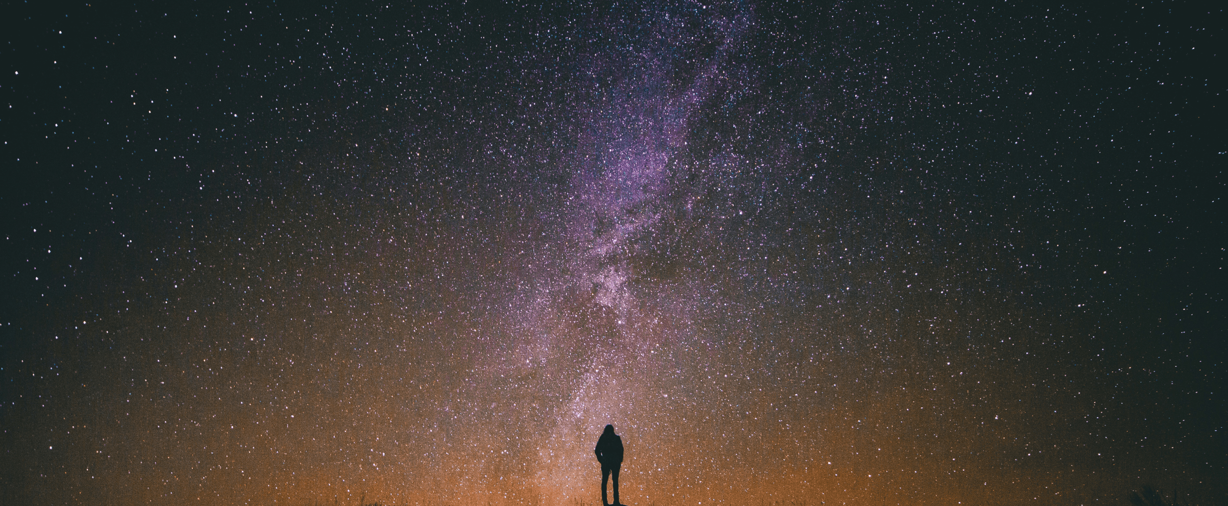 A person stares at a sky full of stars and the balance of the universe