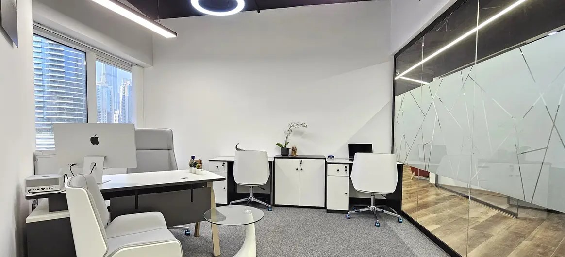 Fully equipped modern workspace with ergonomic furniture and sleek glass partitions in a prime office tower.