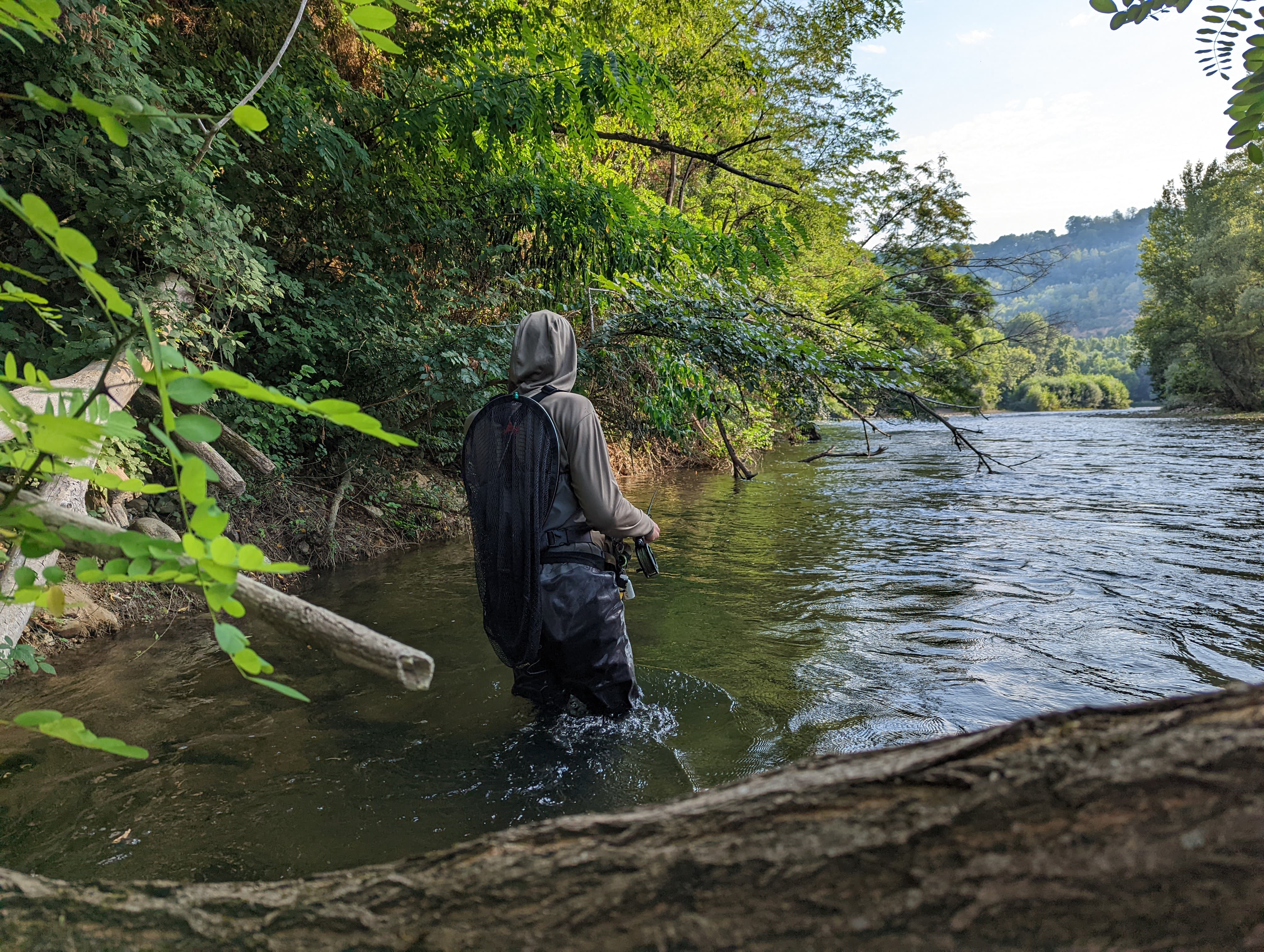 Fly fishing Vicdessos: an angler wading in a clear river in the Pyrenees.