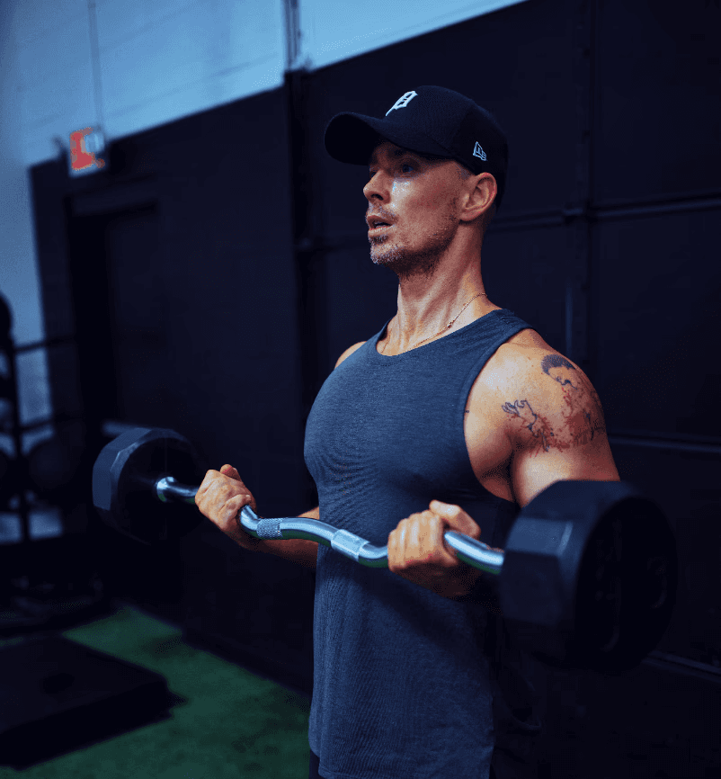 A muscular man in a cap lifting dumbbells outdoors with determination. Text: James Carter – Personal Trainer.