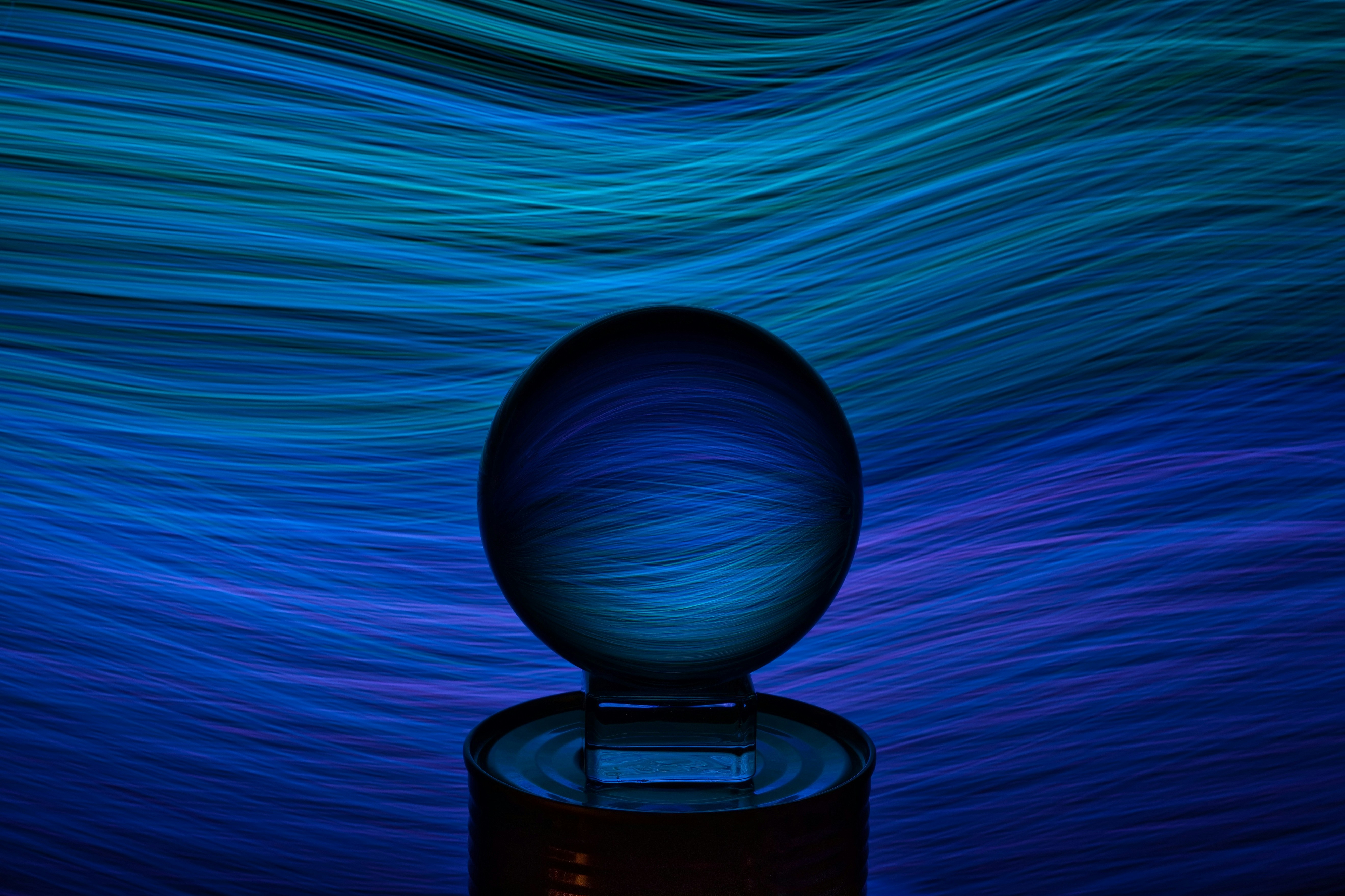 Crystal ball with flowing, blue abstract background.
