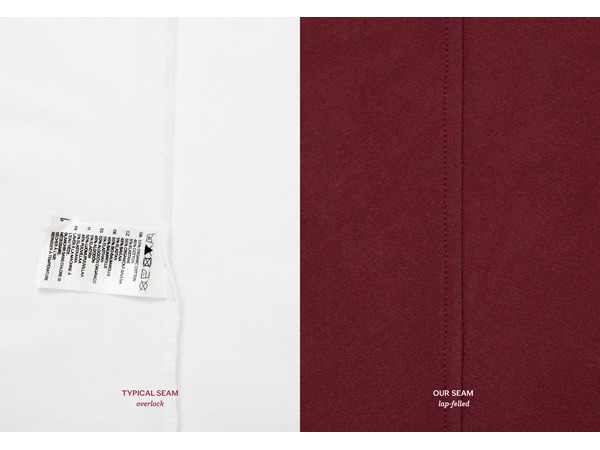 The image shows two close-ups of fabric seams. On the left, a white fabric displays a white tag with black text and symbols, including the words “TYPICAL SEAM” and “overlock”. On the right, a dark red fabric shows the same seam labeled “OUR SEAM lap-felled”. The seams are positioned vertically and parallel to each other.