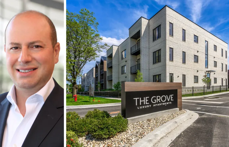 Tall modern skyscraper with vertical lines, viewed against a clear blue sky.