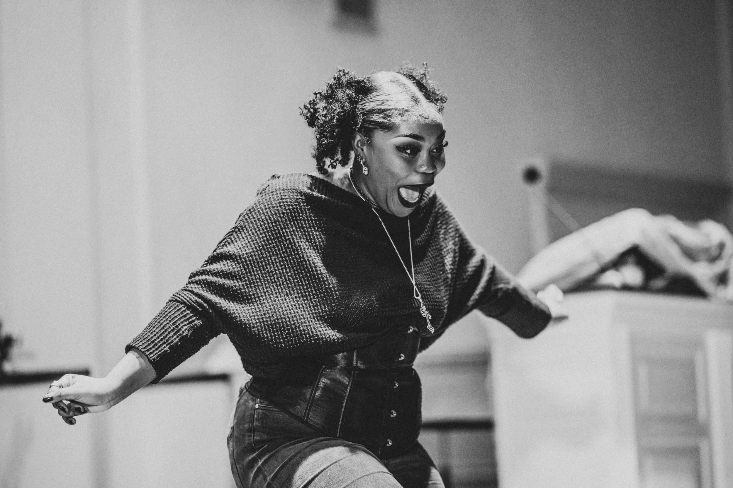 Performer expressing emotion during a live performance at the Queer Open Mic (QOM) hosted by be; community in Bridgewater, Massachusetts.