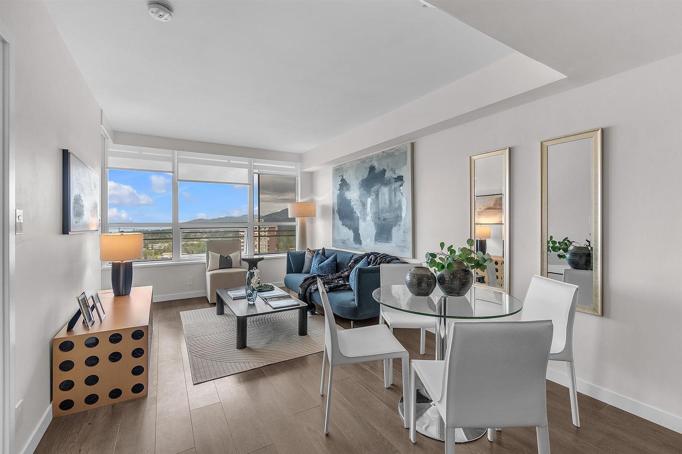 Bright, modern living space with white furniture, a dining area, and large windows showcasing city views.