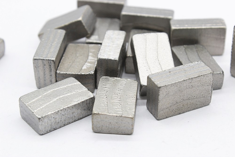 A pile of diamond segment for granite cutting, stacked on a white background tabletop