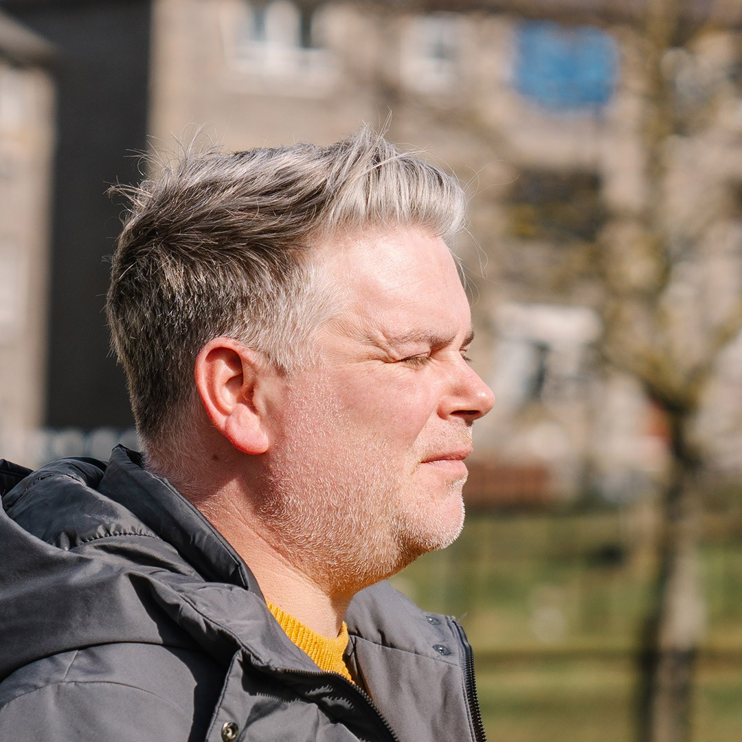 side profile of a man looking into sun and being blinded by it