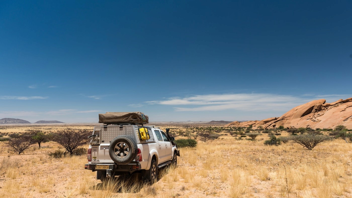 A 4x4 with rooftop tent at a remote Namibian campsite with no other vehicles nearby