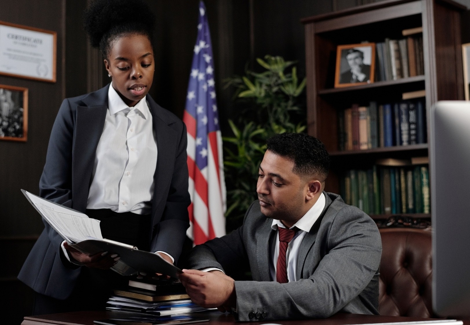 woman in teal t-shirt sitting beside woman in suit jacket