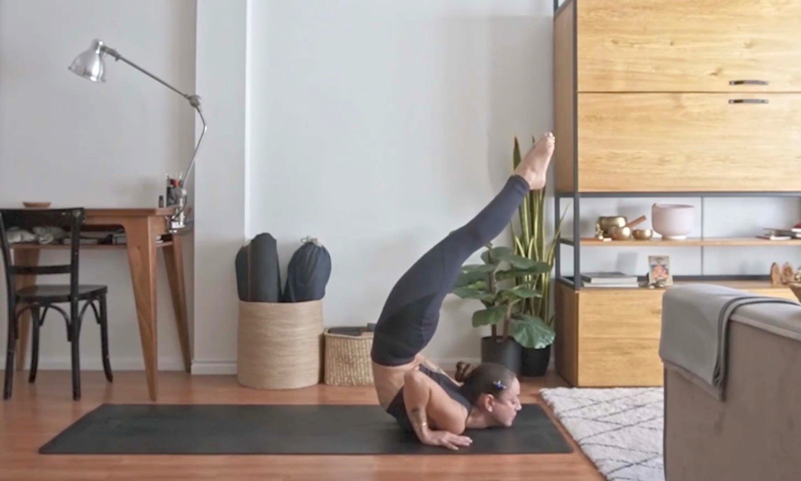 Flavia Siutti practicando una postura invertida con apoyo en hombros sobre la esterilla.
