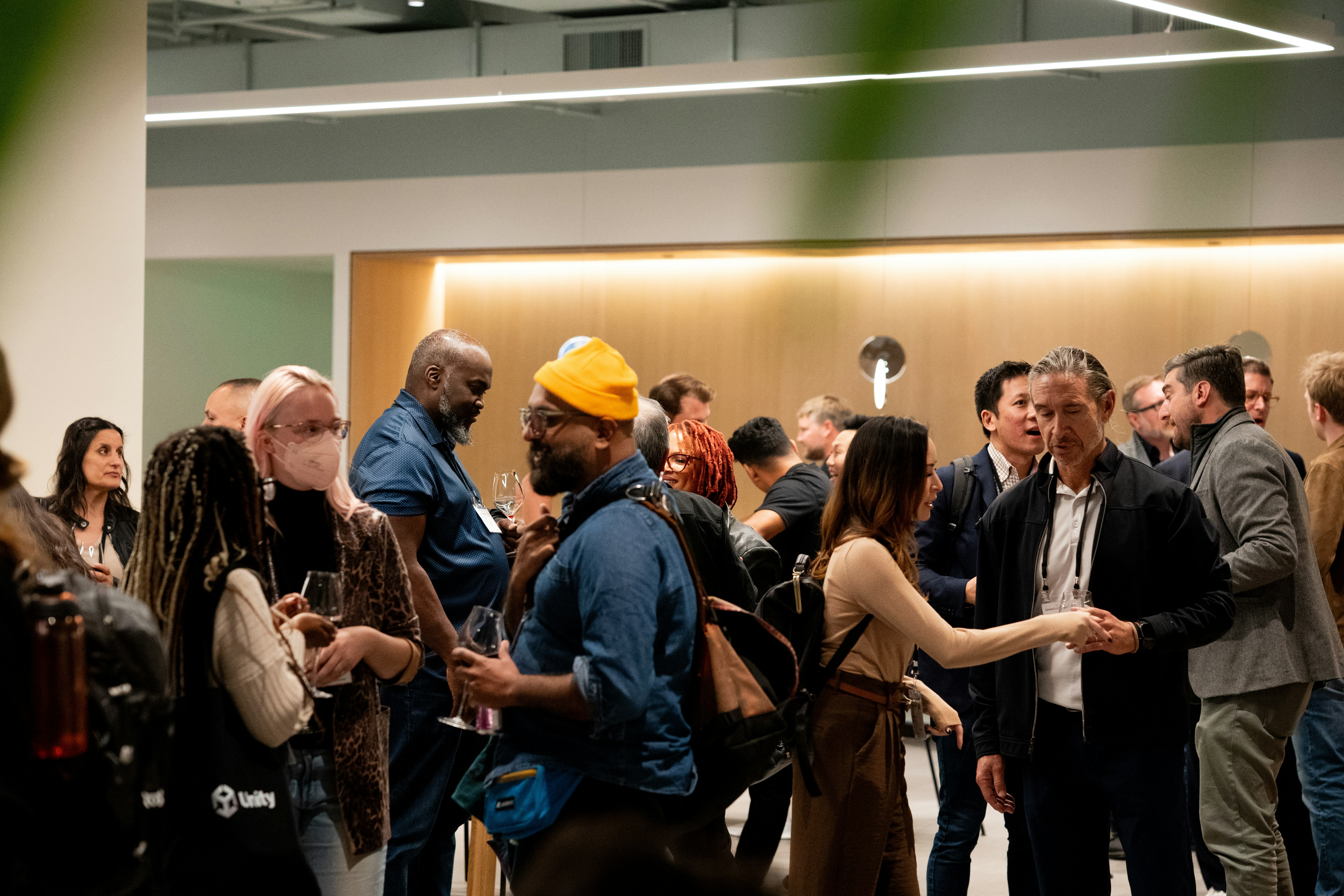 People mingling at an indoor event with warm lighting.