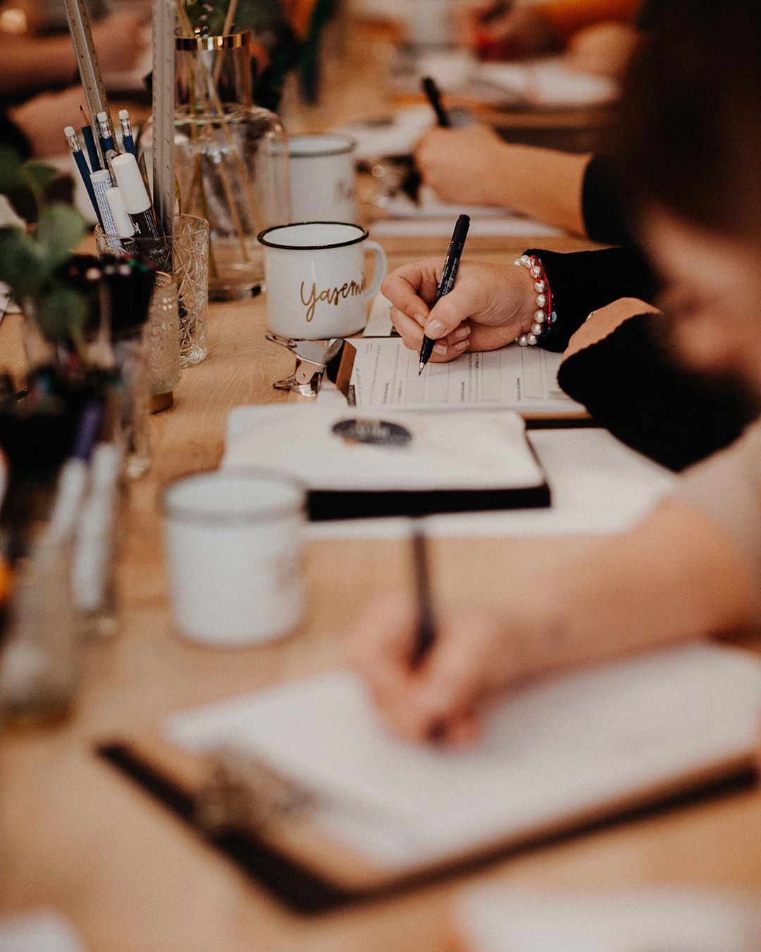 Designer's hands working on a creative project during a hands-on workshop in Tuscany