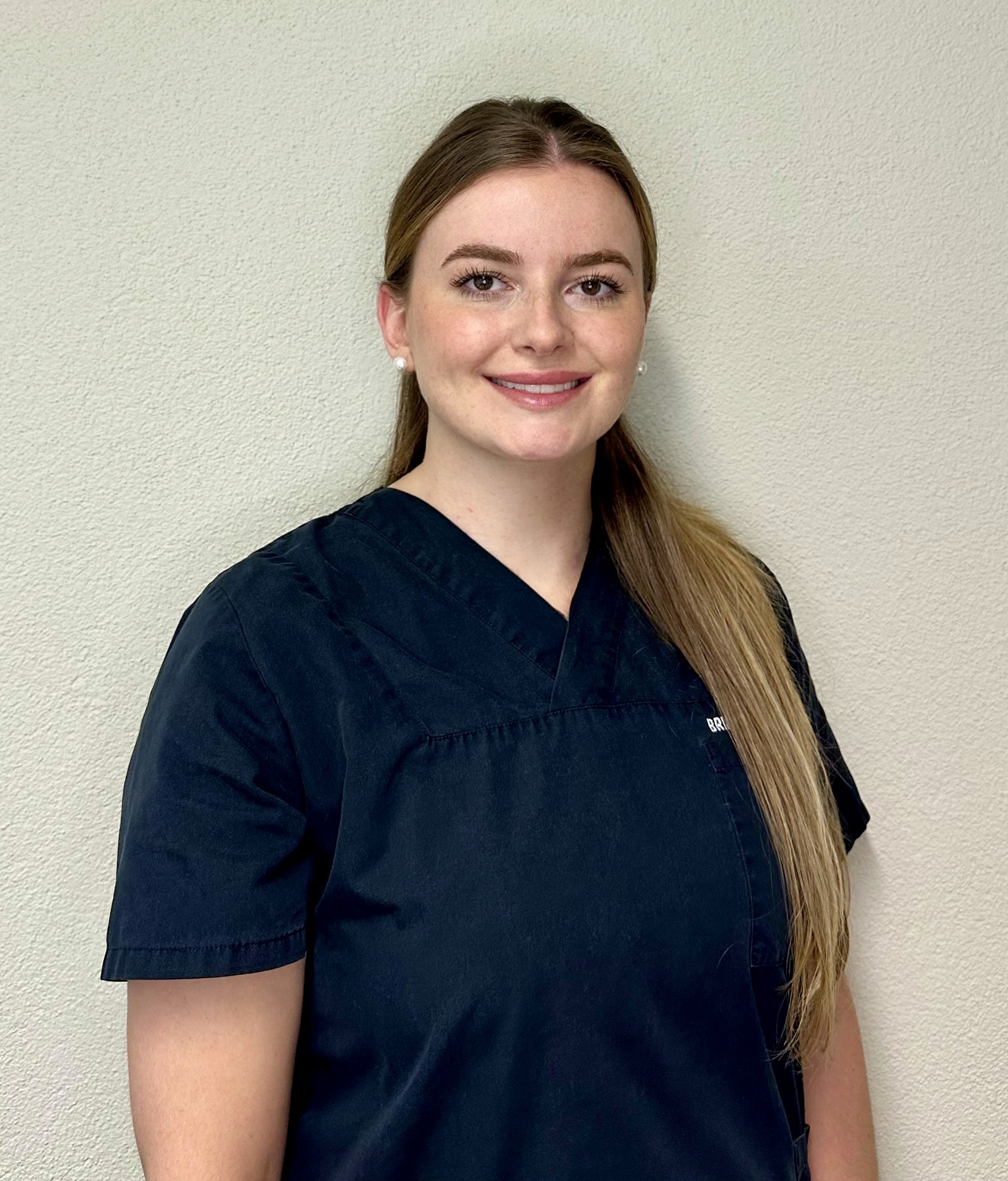 Dentalhygienikerin Julija Vuksanovic im Portrait mit geflochtenem Zopf aus dem Team der Praxis.