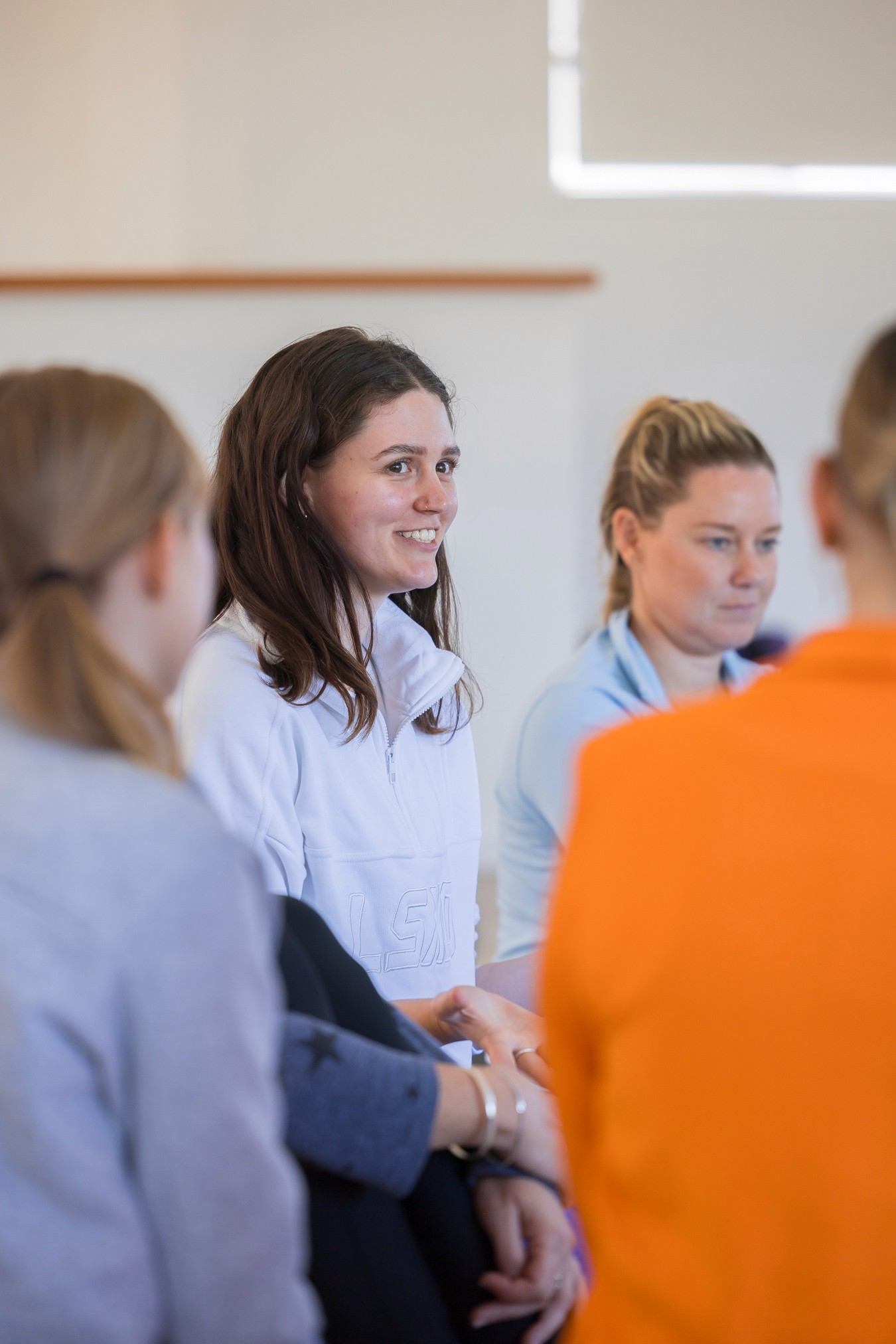 Woman smiling amongst other women