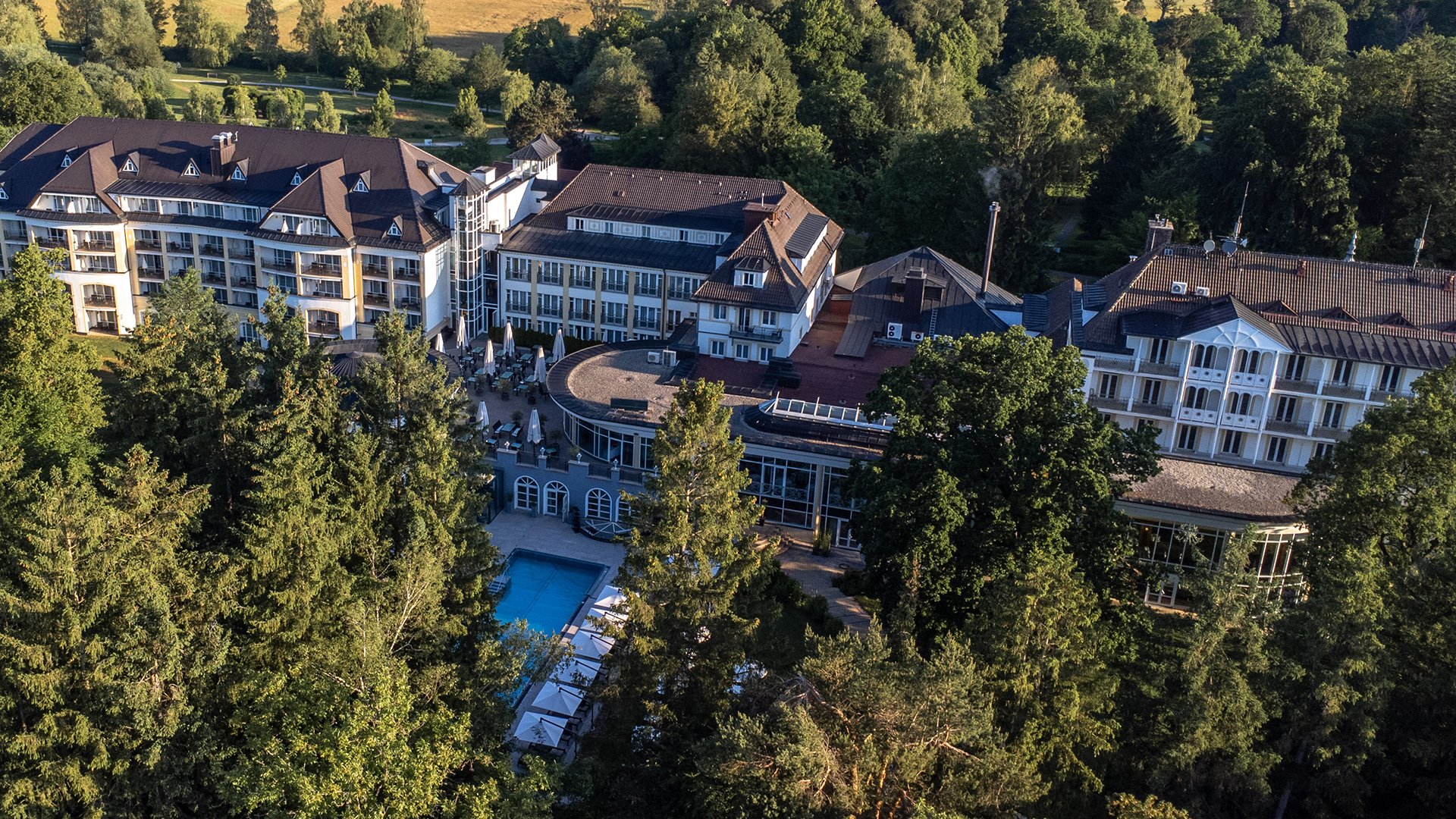 Außenansicht Steigenberger Hotel der Sonnenhof umgeben von Bäumen.