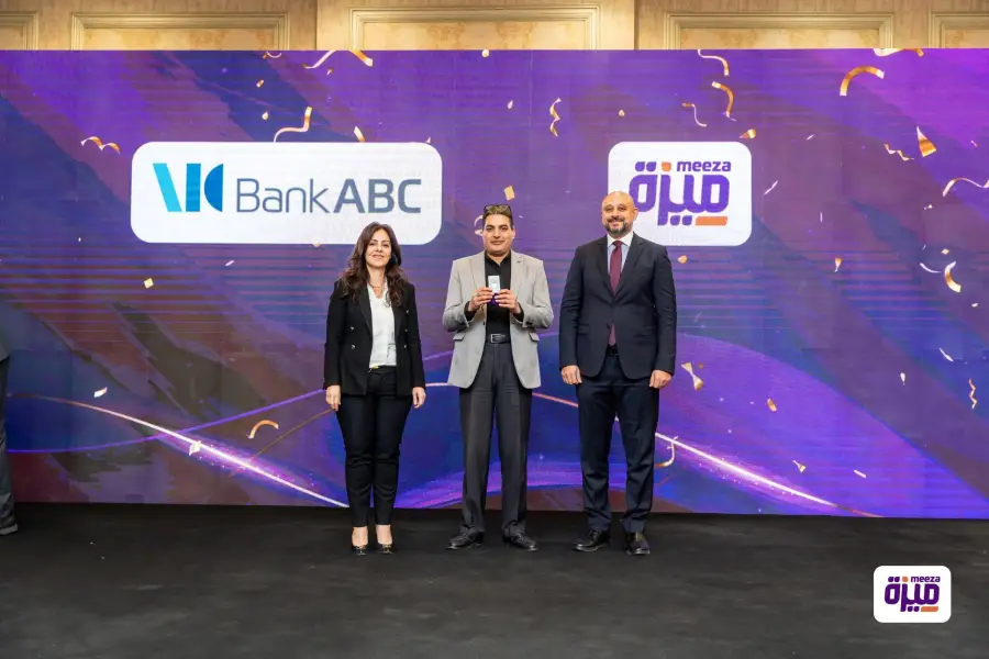 Prize recipient with event representatives in front of a Bank ABC backdrop