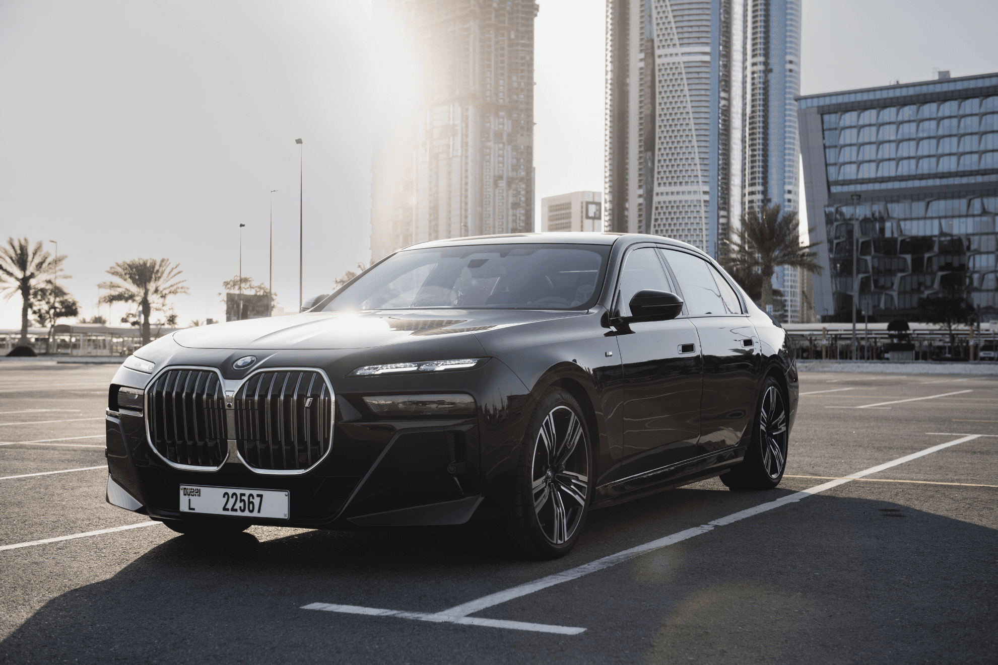 BMW i7 in a parking lot front of a modern building with a glass facade