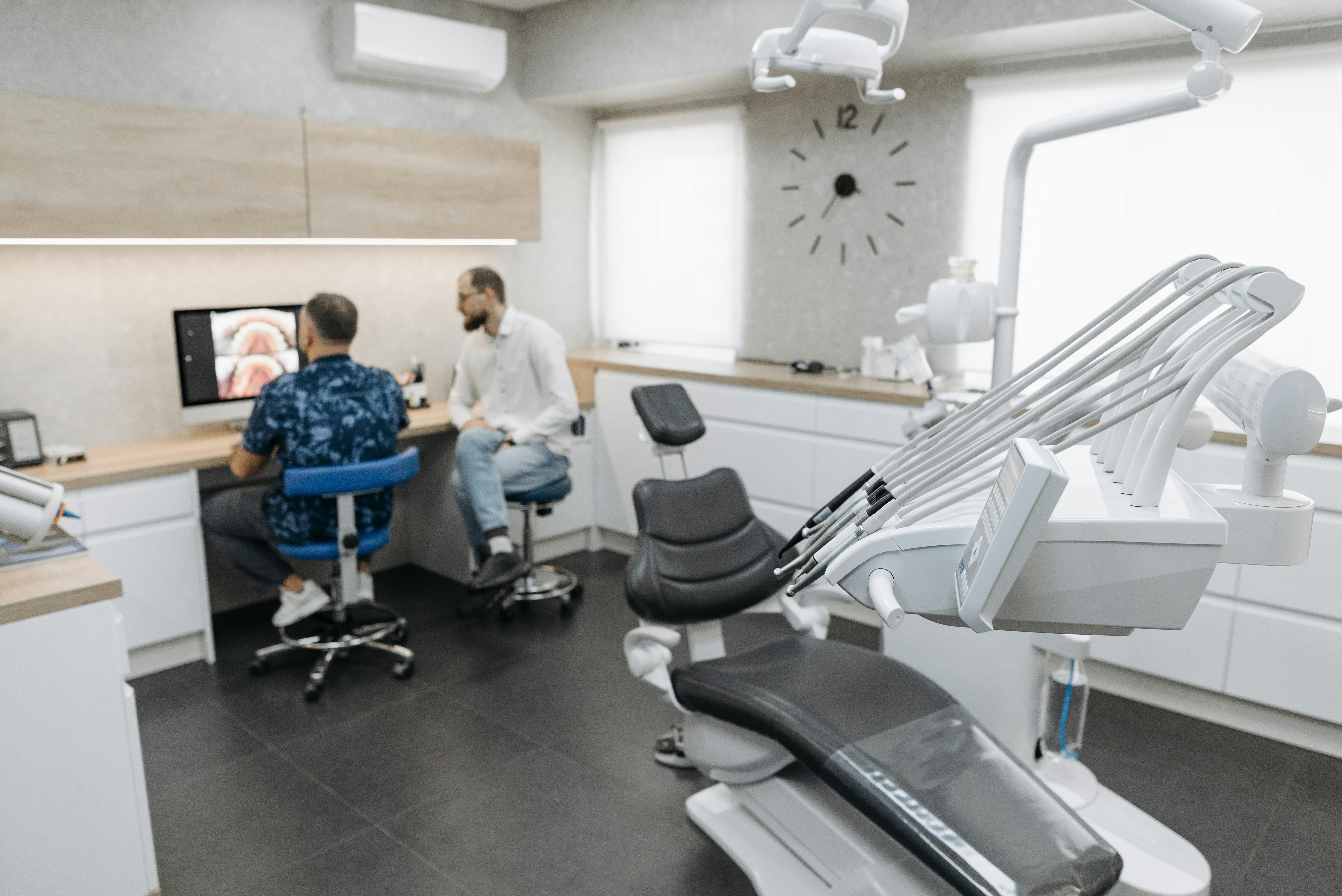 Dentists looking at computer screen in operatory