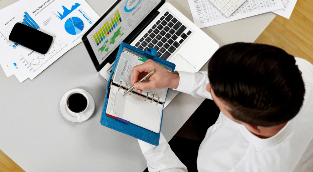 Person reviewing charts and taking notes, representing real-time data access for operational and strategic success