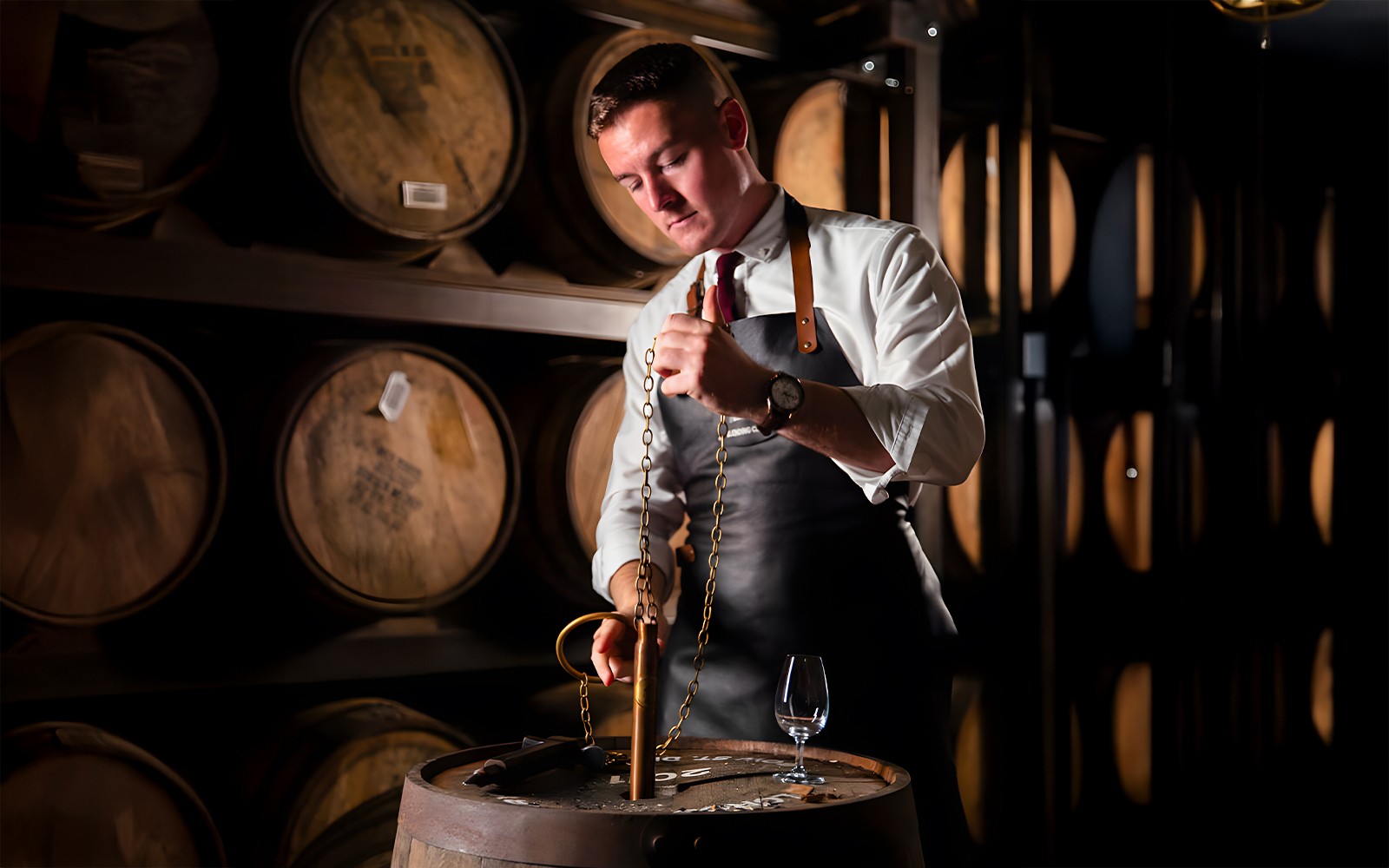 Man blending whiskey at Jameson Distillery Black Barrel class, surrounded by barrels.
