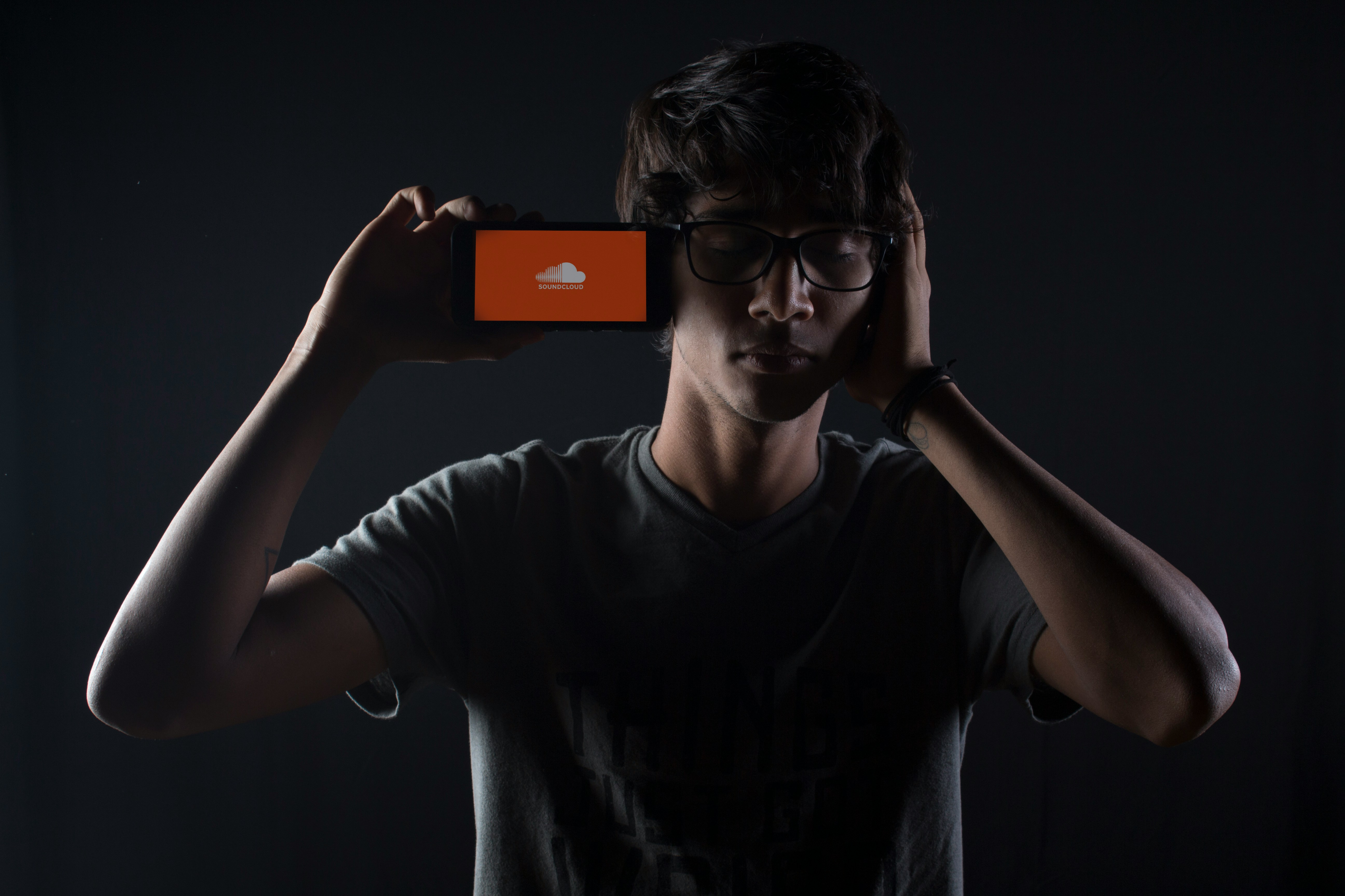 guy holding phone with soundcloud logo