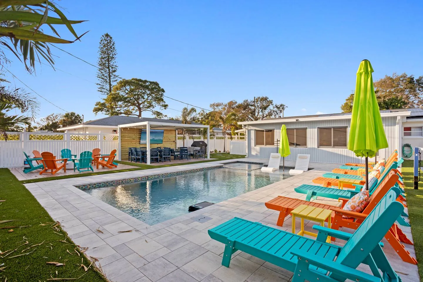 Pool with colorful loungers, umbrellas and pavilion at Pickleball Resort, Bradenton, Florida