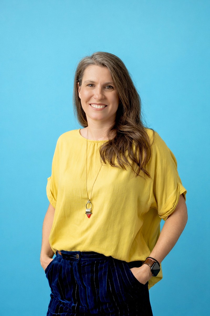 Deni explaining how to design for Autism in front of a laptop