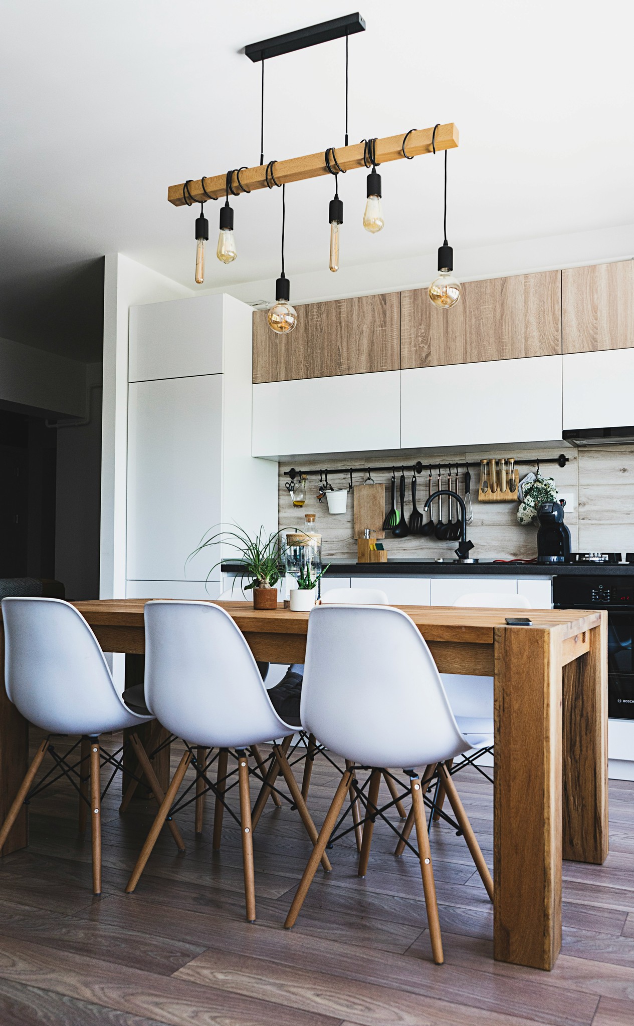 Kitchen dining area with timber chairs and hanging cookware